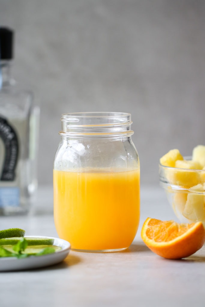 Photo of a mason jar filled with orange juice for for the Frozen Pineapple Margaritas