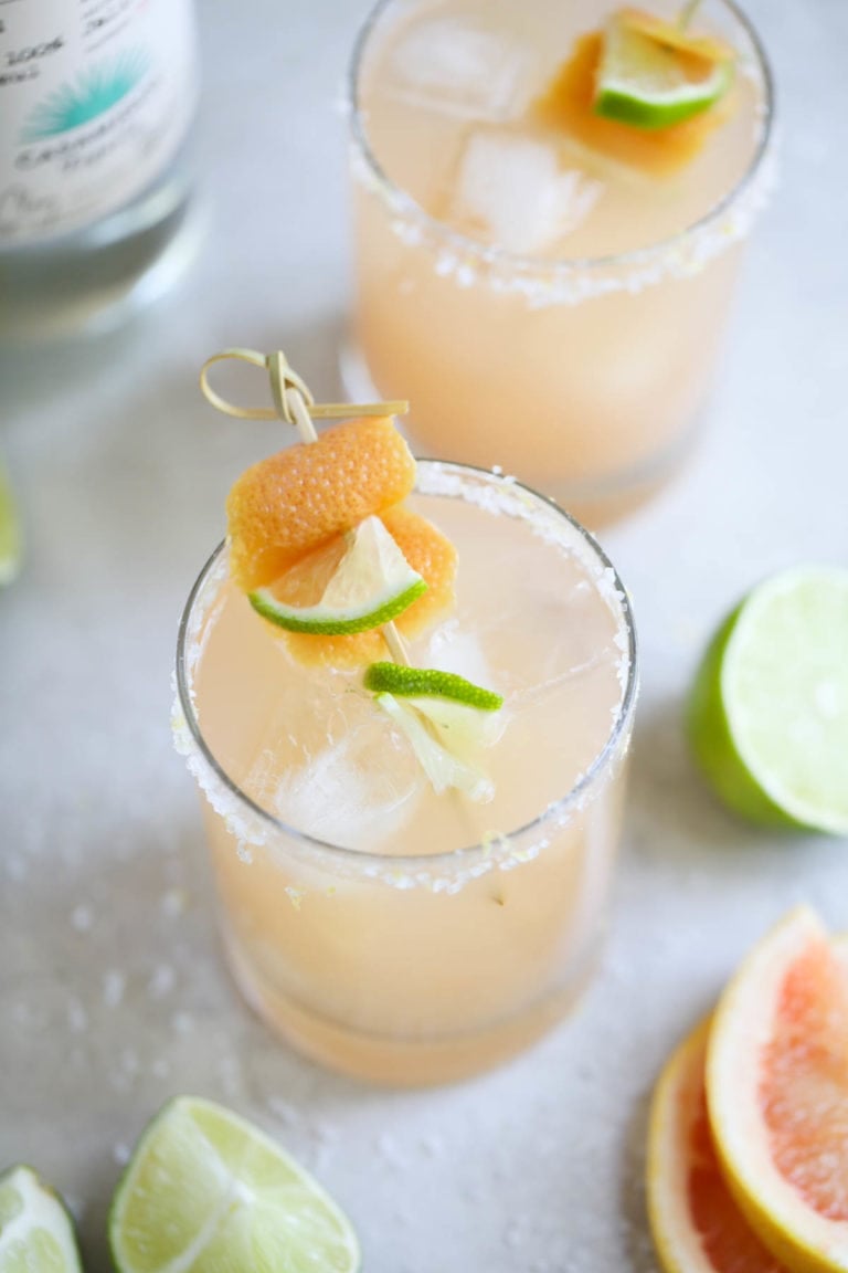 Two glasses of freshly made low sugar palomas with a mix of grapefruit and lime juices. 