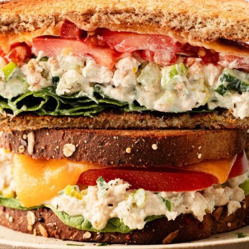 Close up view of two stacked tuna melt sandwiches.