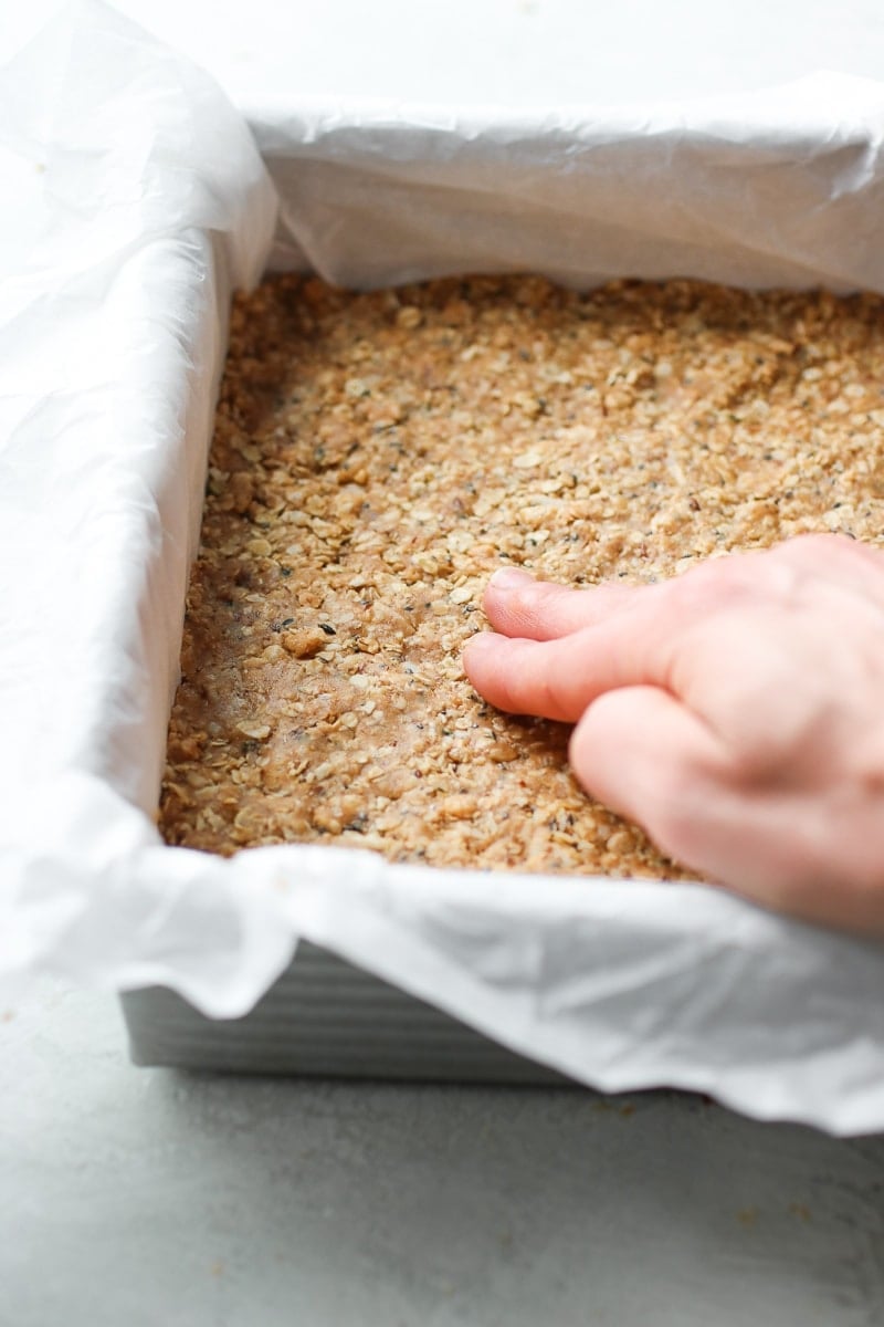 Photo of the No-Bake Peanut Butter Crunch Bars being pressed into a pan