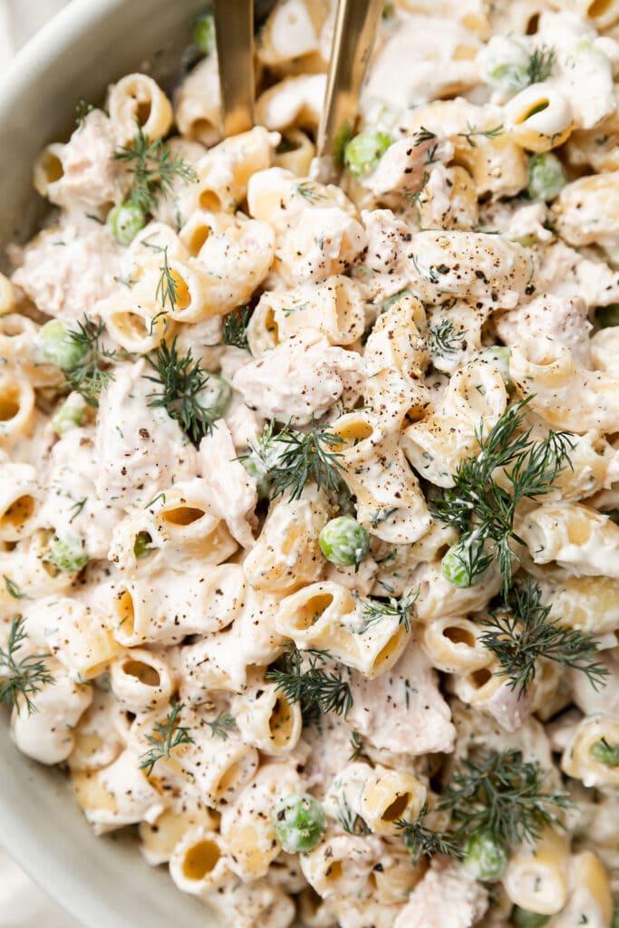 Close up view tuna pasta salad with creamy dressing over noodles.