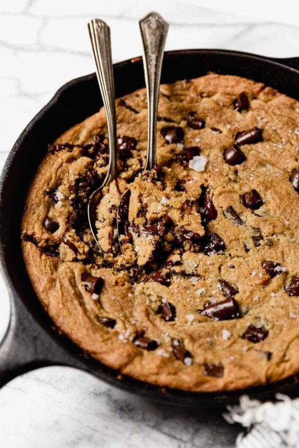 Vegan Chocolate Chip Cookie Skillet with two spoons in the cookie ready for serving.