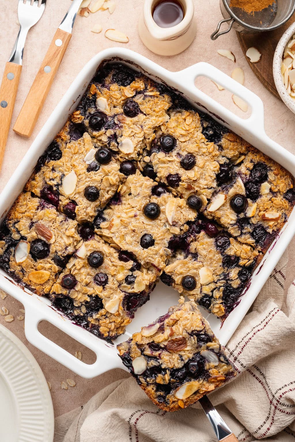 Overhead view of a white baking dish filled with blueberry baked oatmeal cut into 9 squares.