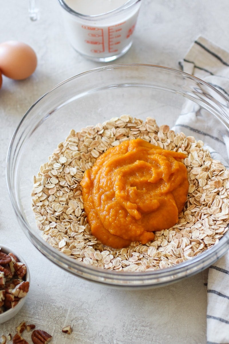 A clear bowl holding oats and pumpkin puree for the Pumpkin Baked Oatmeal