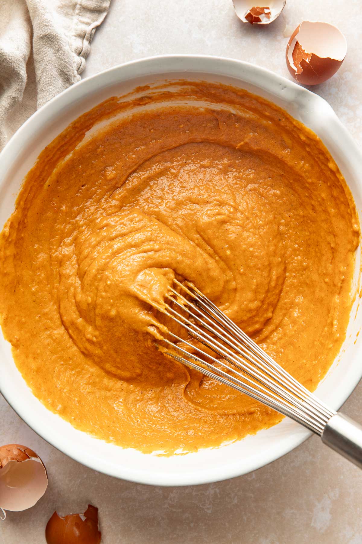 Pumpkin bread batter being whisked in a bowl.