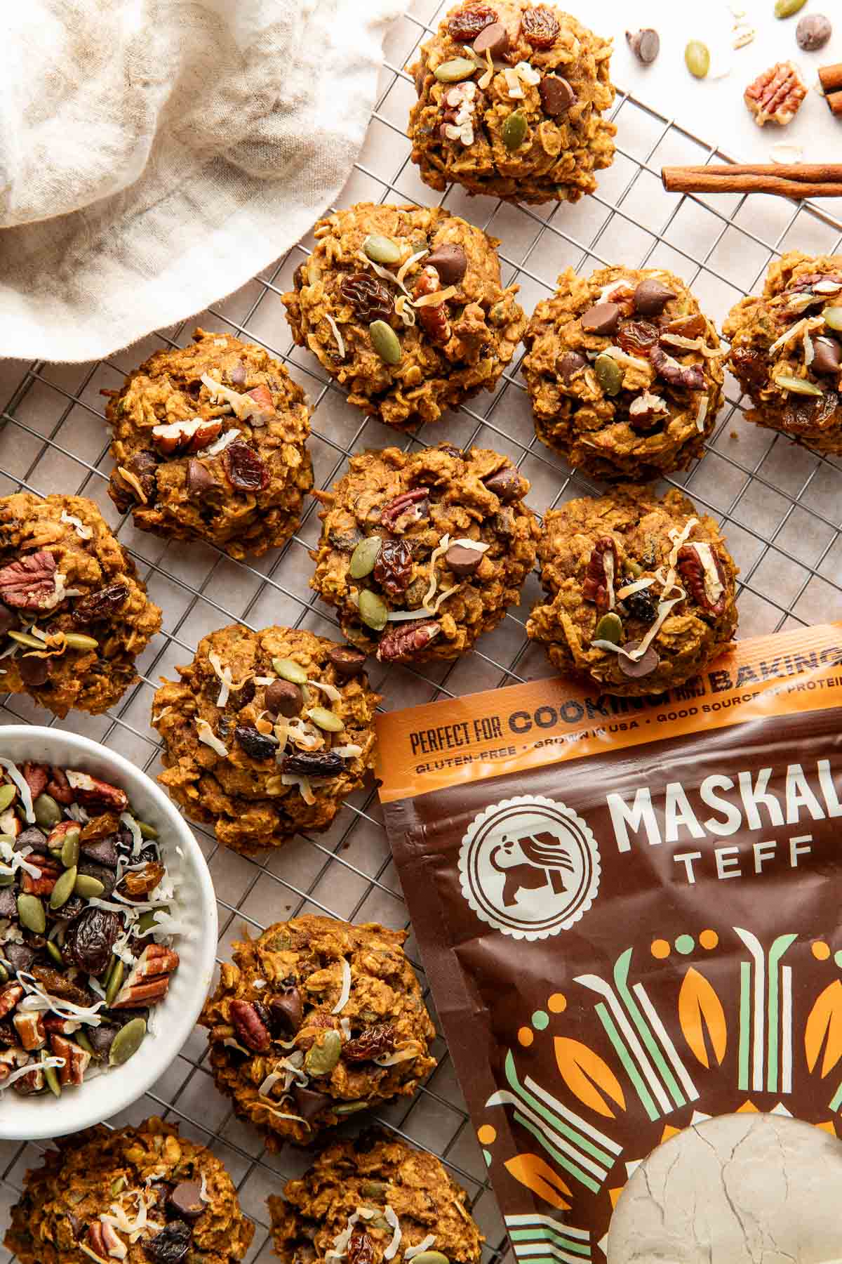 Pumpkin breakfast cookies on a wire rack next to a bag of teff flour.