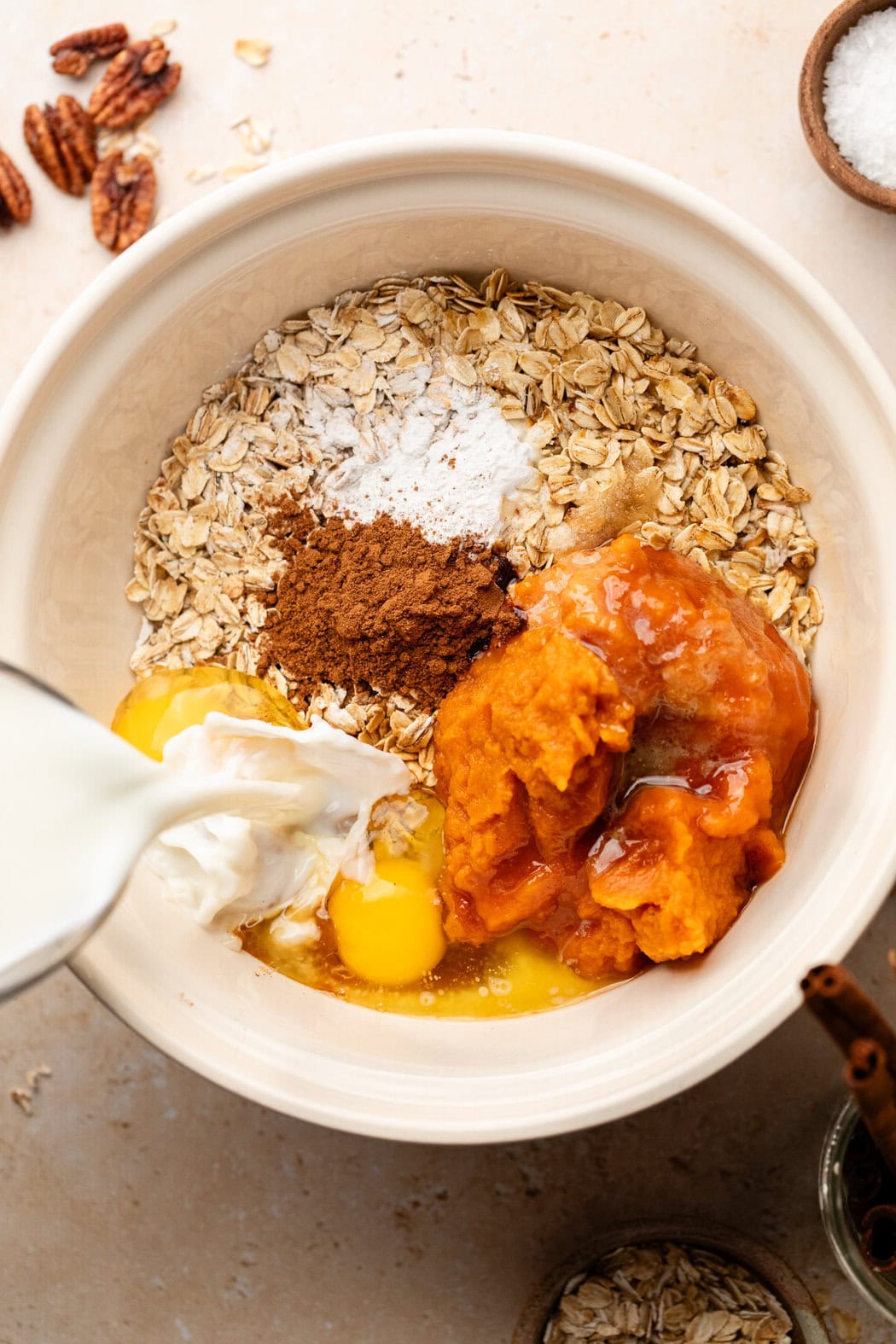 Overhead view of a bowl of ingredients for Pumpkin Baked Oatmeal ready to be mixed. 