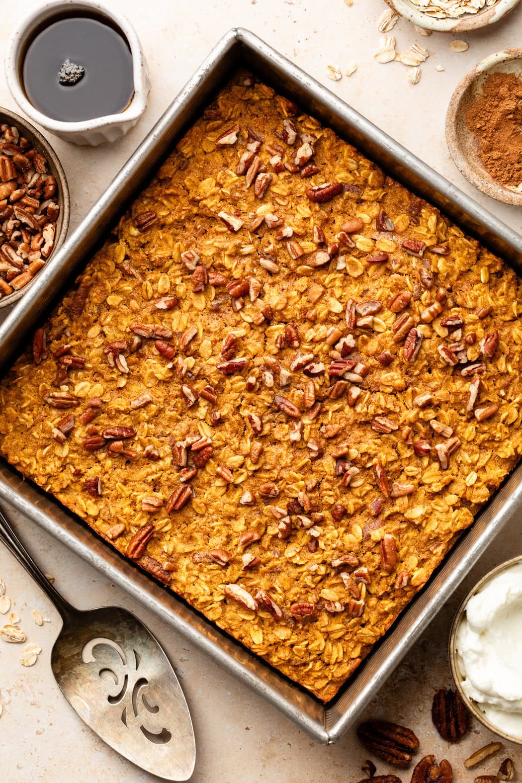 Overhead view of a freshly baked pan of Pumpkin Baked Oatmeal topped with pecans. 