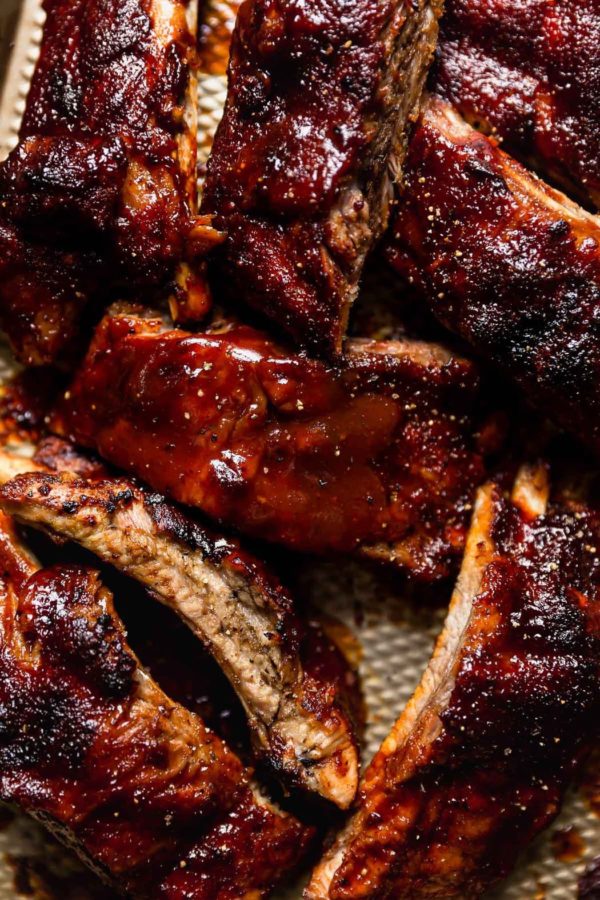 Close up view of caramelized BBQ baby back ribs on a baking sheet