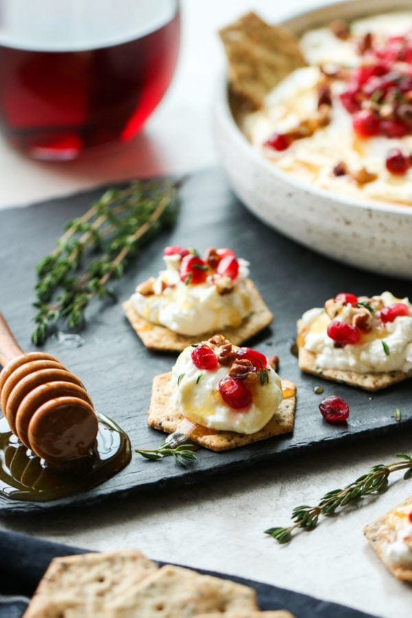 Honey Whipped Goat Cheese with Pomegranate served on top of crackers.
