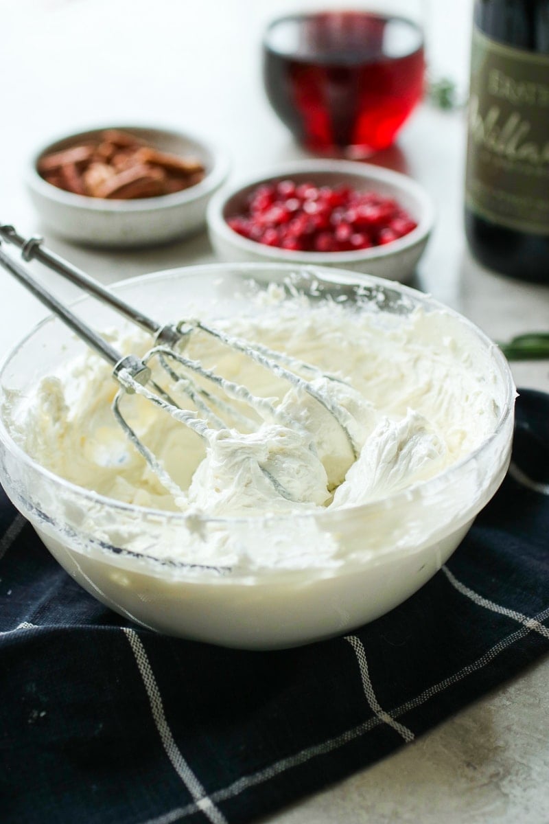 Whipped goat cheese in a clear mixing bowl.