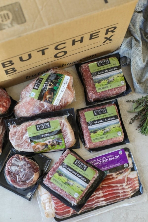 Overhead view Butcher Box packaged meat in front of cardboard box with Butcher Box logo on side.