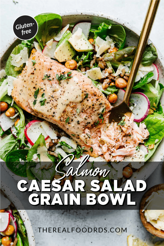 A large salmon caesar salad grain bowl with a caesar dressing marinated salmon fillet on top