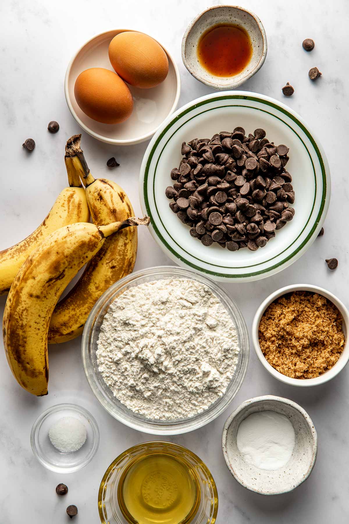 Overhead view of a variety of ingredients for Gluten-Free Banana Muffins in different sized bowls. 