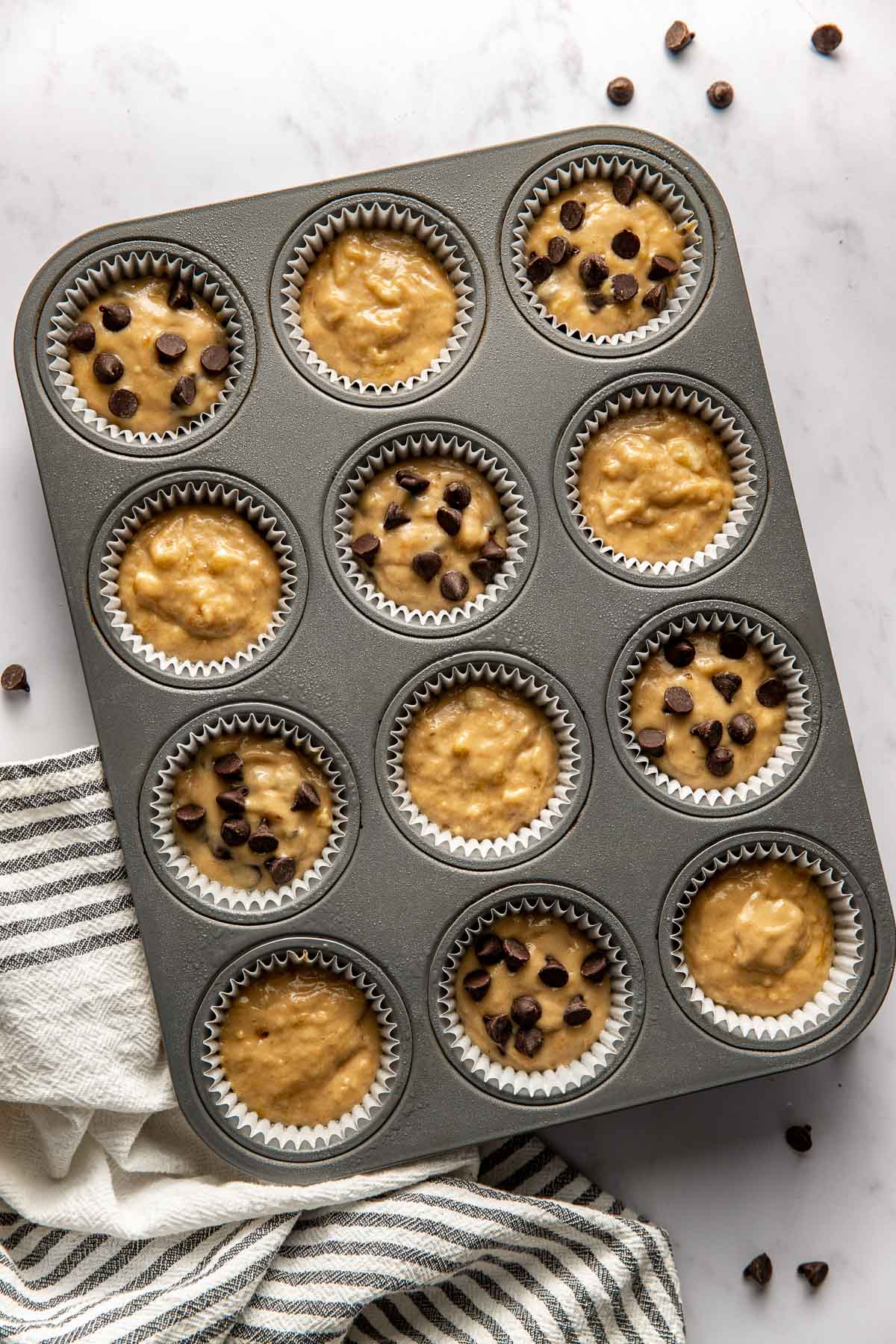 Overhead view of a muffin pan filled with Gluten-Free Banana Muffin batter. 