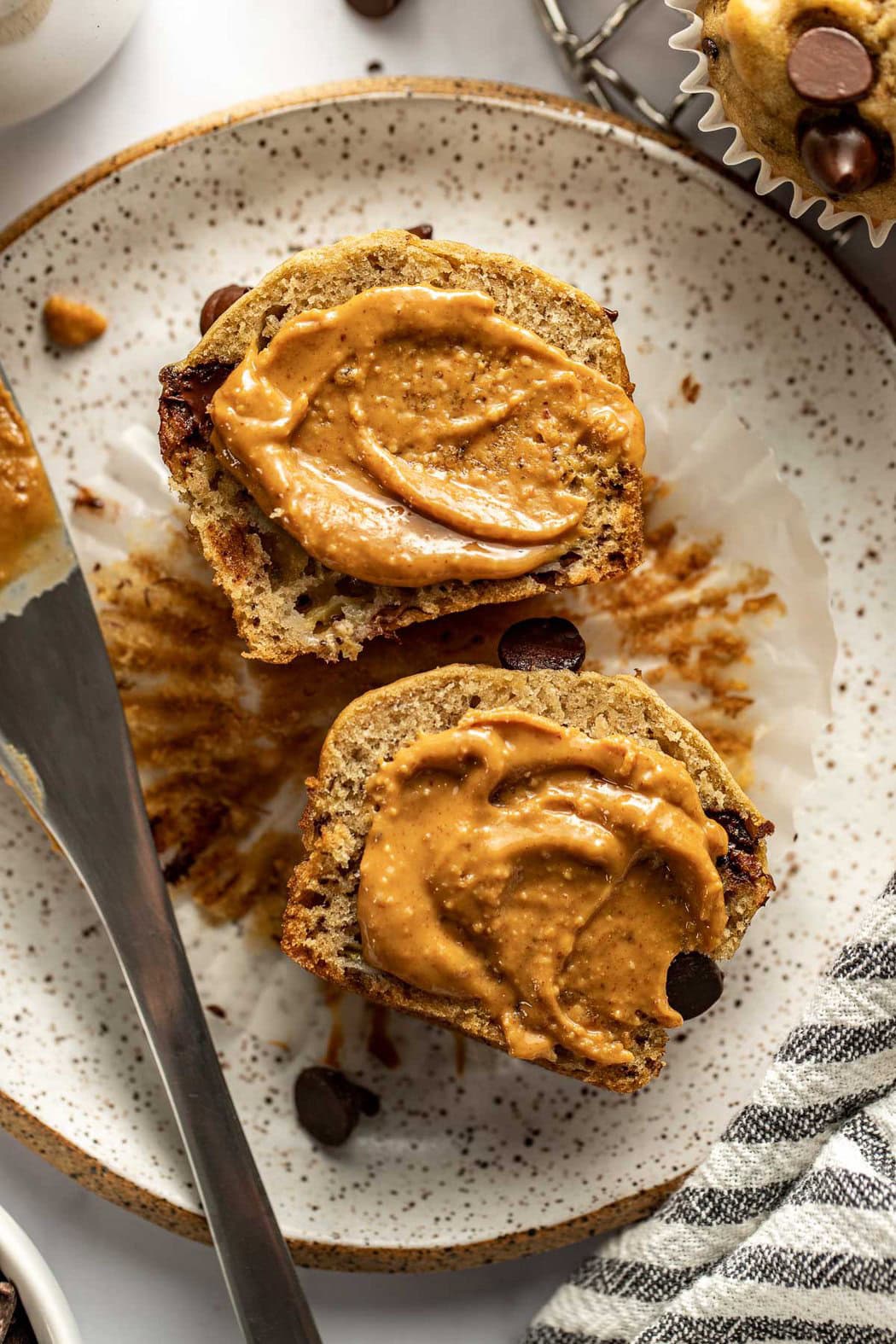 Overhead view of a Gluten-Free Banana Muffin with peanut butter spread on it. 