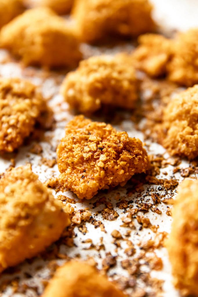 Close up view breaded chicken nugget on baking sheet