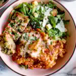 Overhead view of easy skillet lasagna in a bowl with a side salad and garlic bread