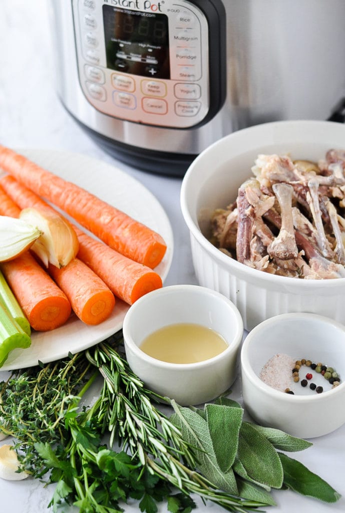 All ingredients for bone broth in white bowls in front of an Instant Pot