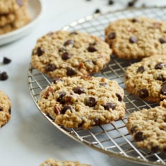 Freshly baked oatmeal chocolate chip cookies on a gold cooling rack