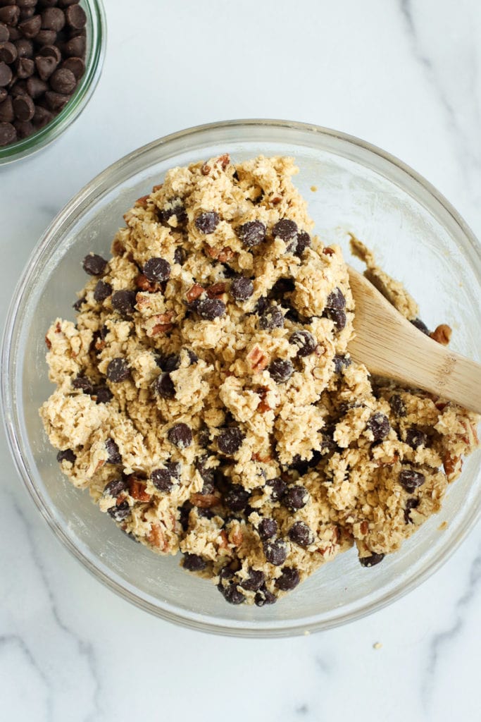 Oatmeal chocolate chip cookies with pecan cookie dough mixed together in a glass bowl