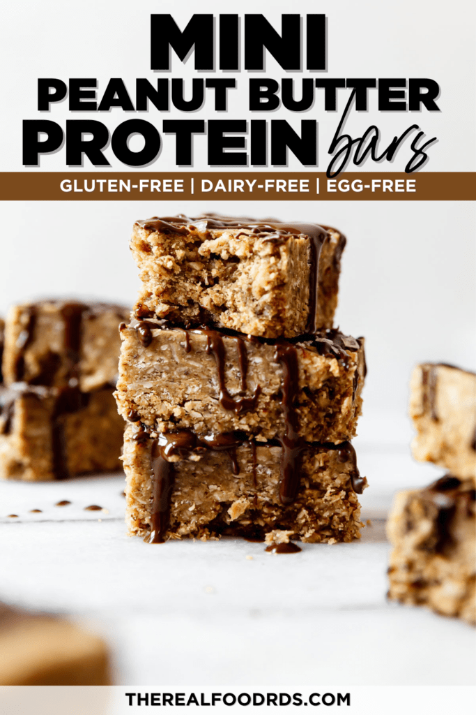 Three mini peanut butter protein bars stacked on each other drizzled with dark chocolate