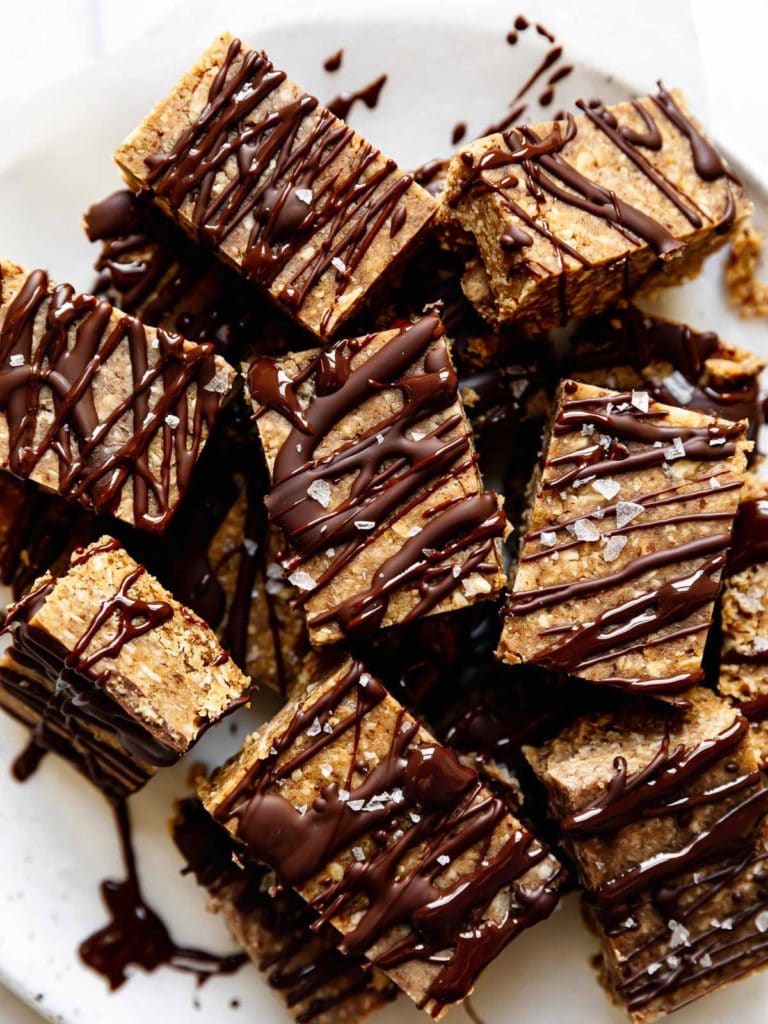 A plate of mini peanut butter protein bars topped with flakey sea salt. 
