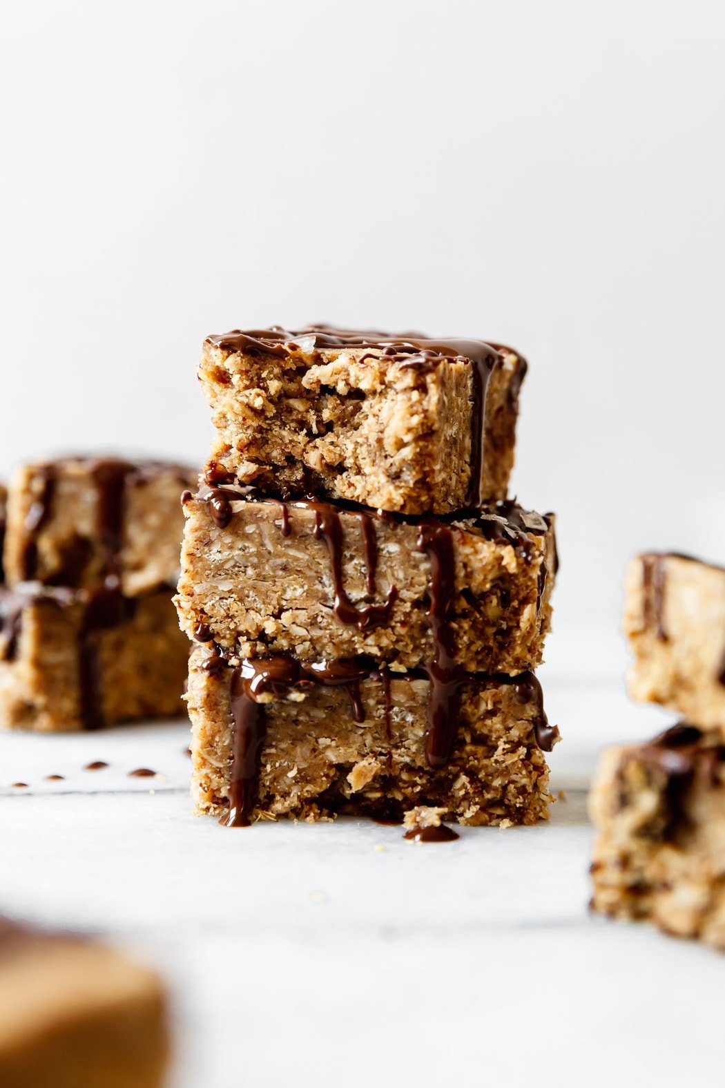 Three mini peanut butter protein bars stacked on top of each other with a bite taken out of the top bar