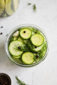 An overhead view of refrigerator dill pickles slices in a mason jar