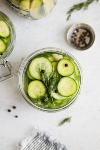 An overhead view of cucumber slices in a jar for easy dill refrigerator pickles