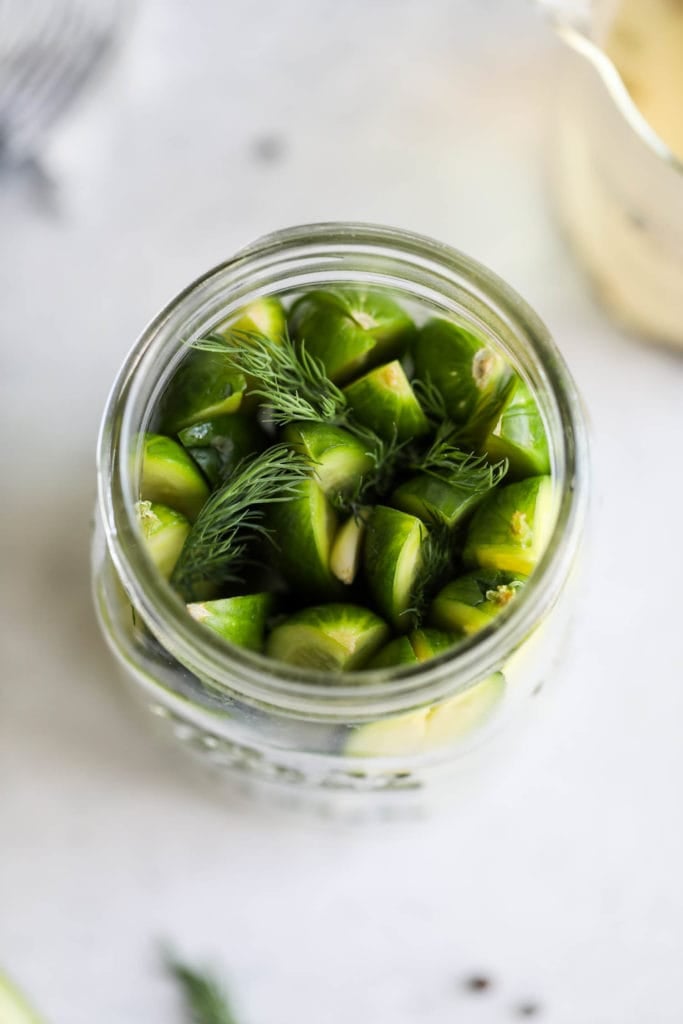 An overhead view of cucumber spear in a mason jar