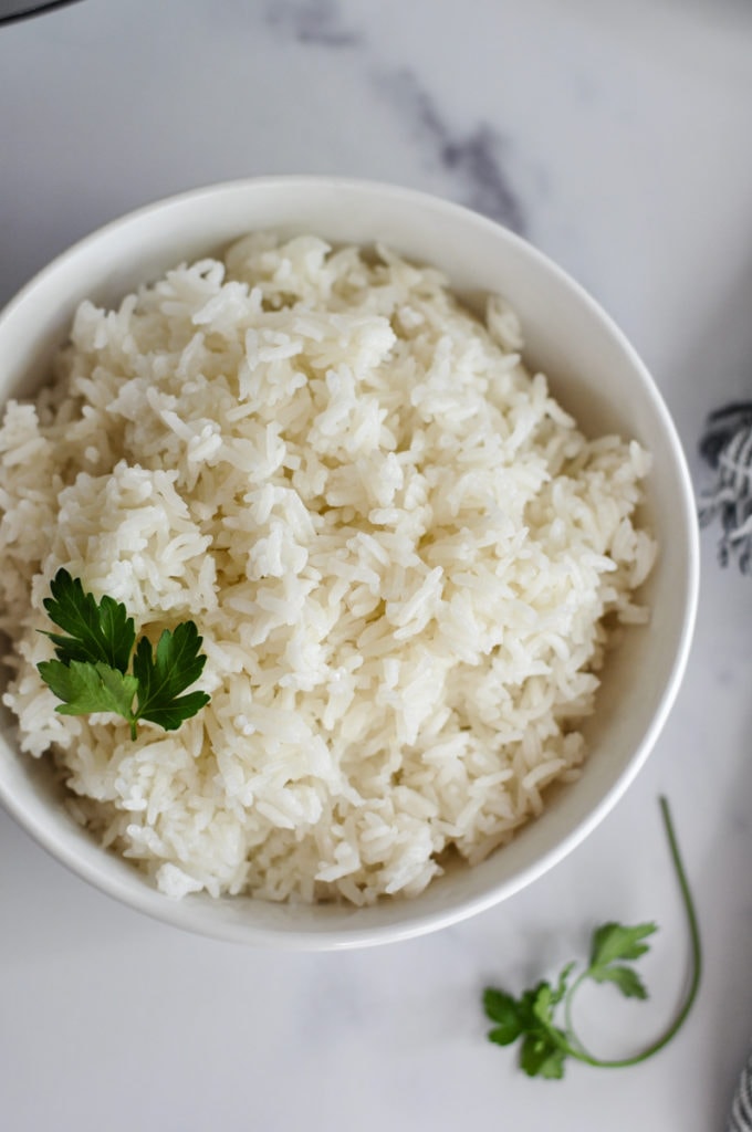 A bowl of Instant Pot Jasmine Rice with a basil leaf on top