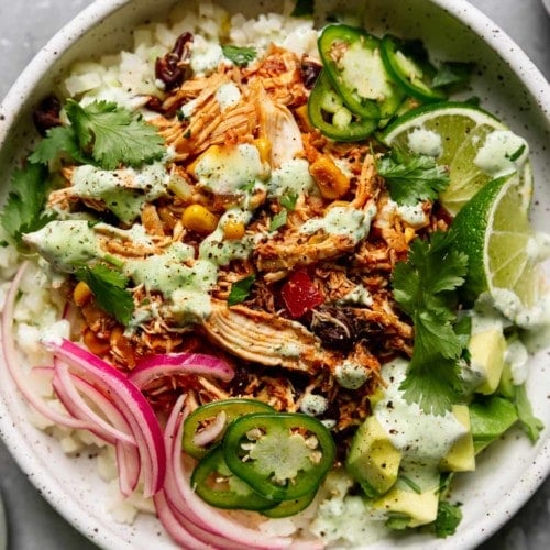 Overhead view white bowl filled with instant pot salsa chicken served over rice and lettuce