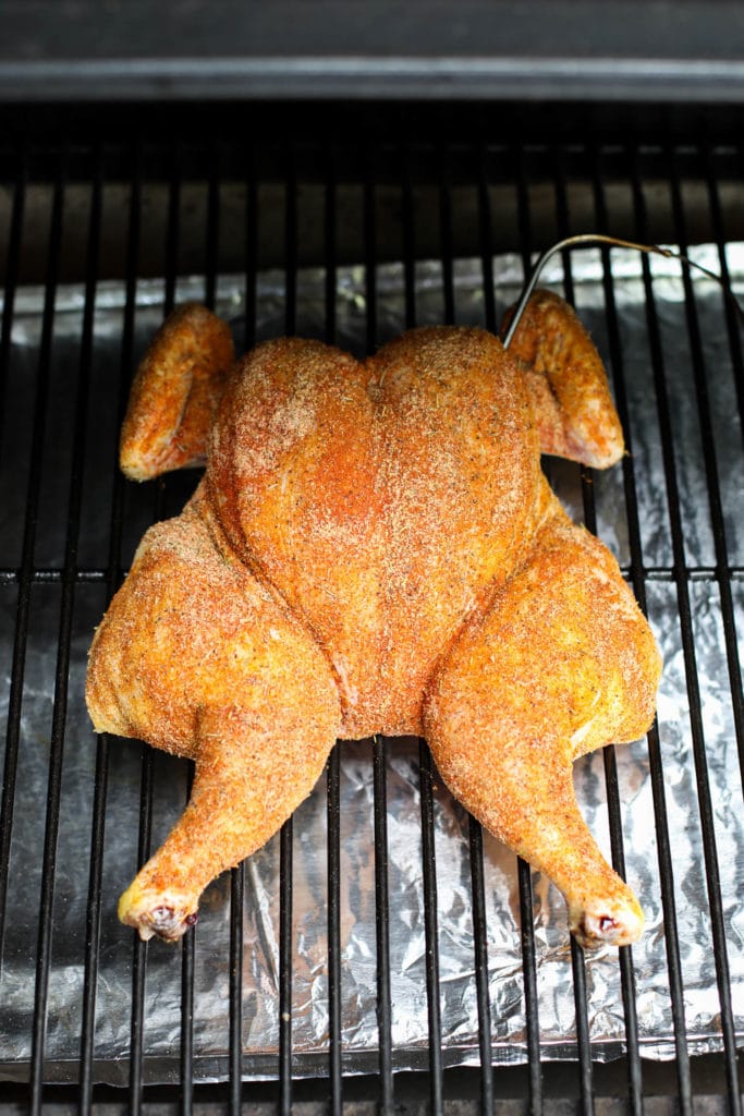 A spatchcock chicken on a grill breast-side up