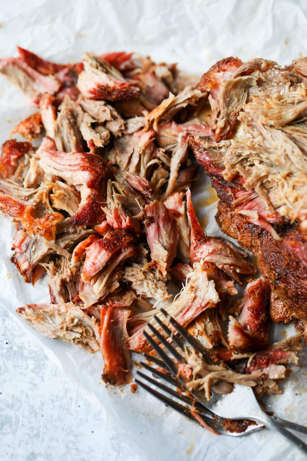 Partially shredded pork butt on a counter