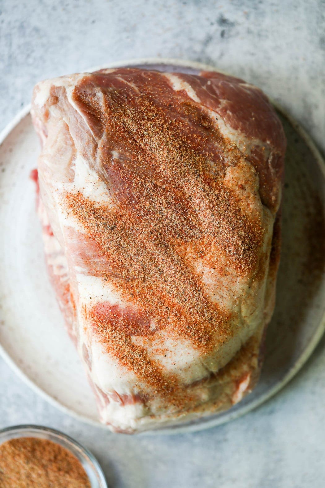 Raw pork butt with a sprinkle of homemade rub on top