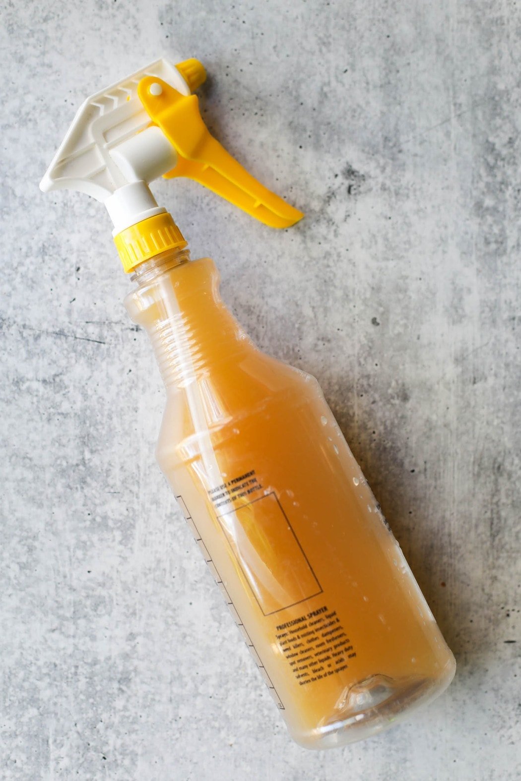 A food-grade plastic spray bottle filled with apple juice