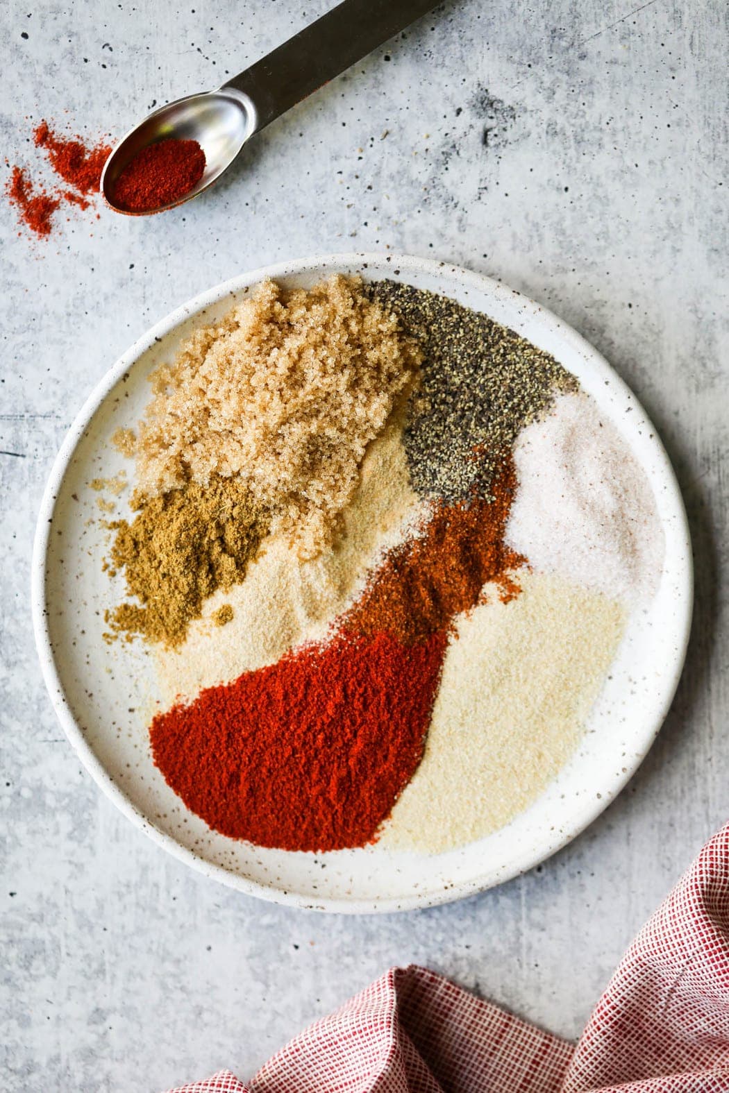 All seasonings for smoked pork butt on a speckled plate