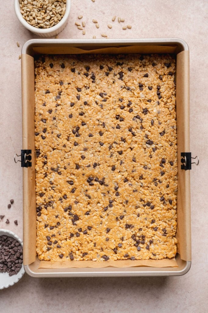Homemade Clif bar batter setting on a parchment paper-lined baking sheet. before being cut into bars.