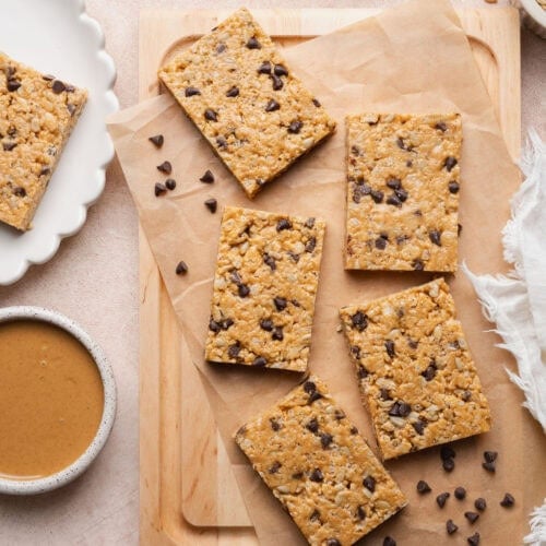 Five homemade Clif bars on a wooden cutting board.