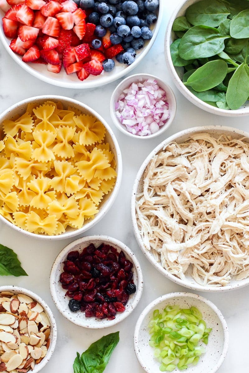 Ingredients for Summer Pasta Salad with Chicken and Berries arranged together in small bowls