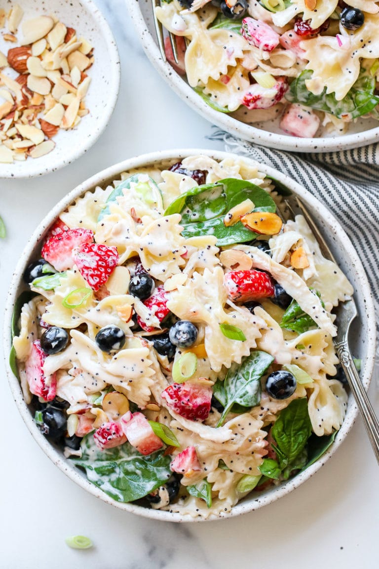 Overhead view of a bowl of summer pasta salad with chicken and berries. 