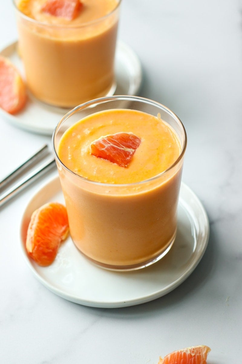 A freshly made orange smoothie in a short glass