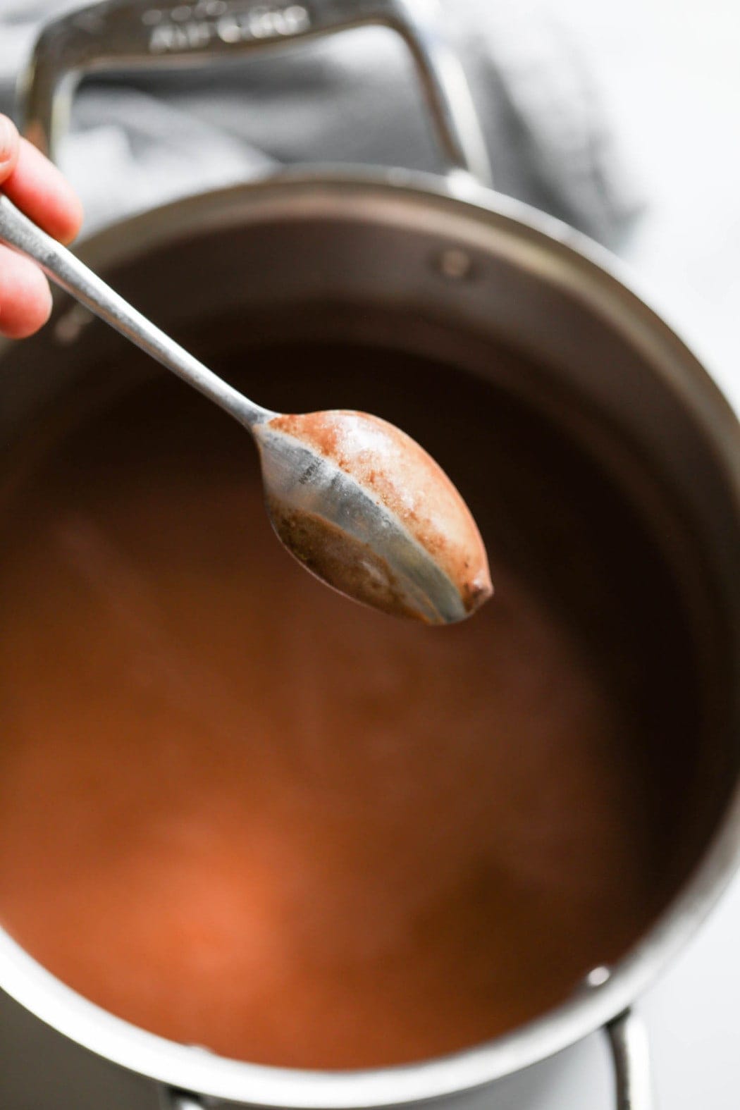 Fudgesicle mixture being stirred in a saucepan
