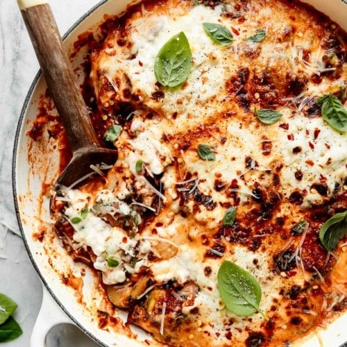Birdseye view of one-skillet zucchini lasagna with melted mozzarella cheese and cottage cheese on top.
