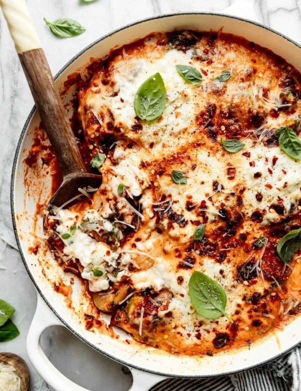 Birdseye view of one-skillet zucchini lasagna with melted mozzarella cheese and cottage cheese on top.
