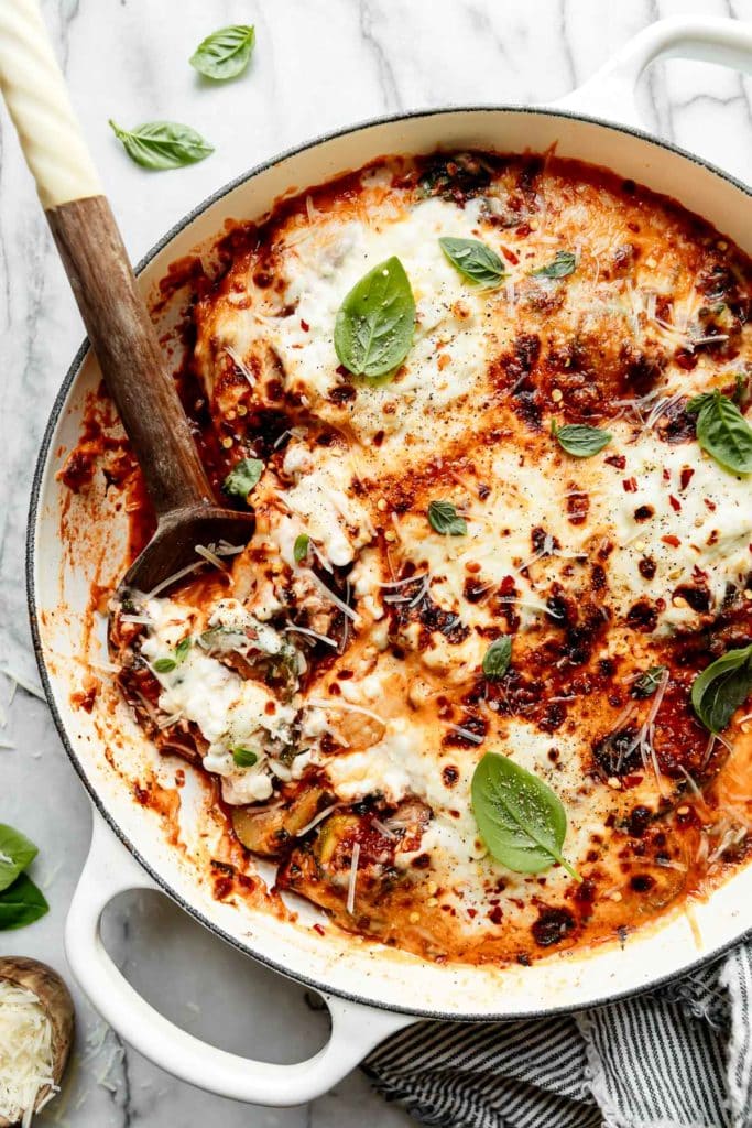 Birdseye view of one-skillet zucchini lasagna with melted mozzarella cheese and cottage cheese on top.