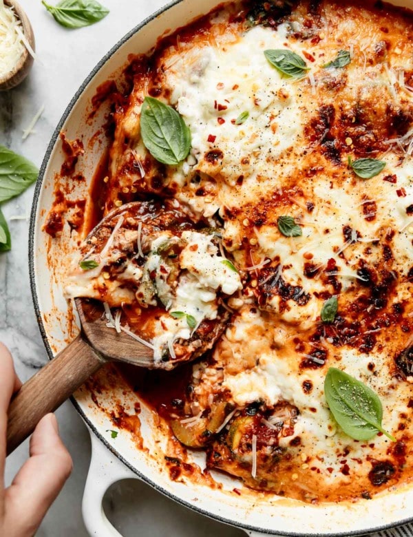 Zucchini lasagna in a skillet topped with melted cheese