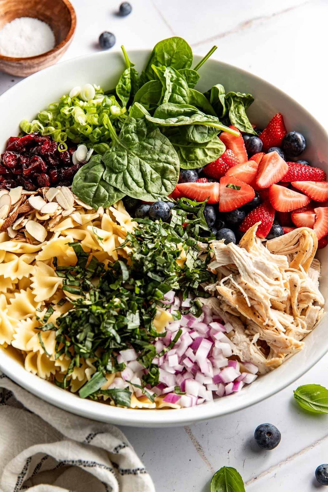 A bowl of summer berry pasta salad ingredients.