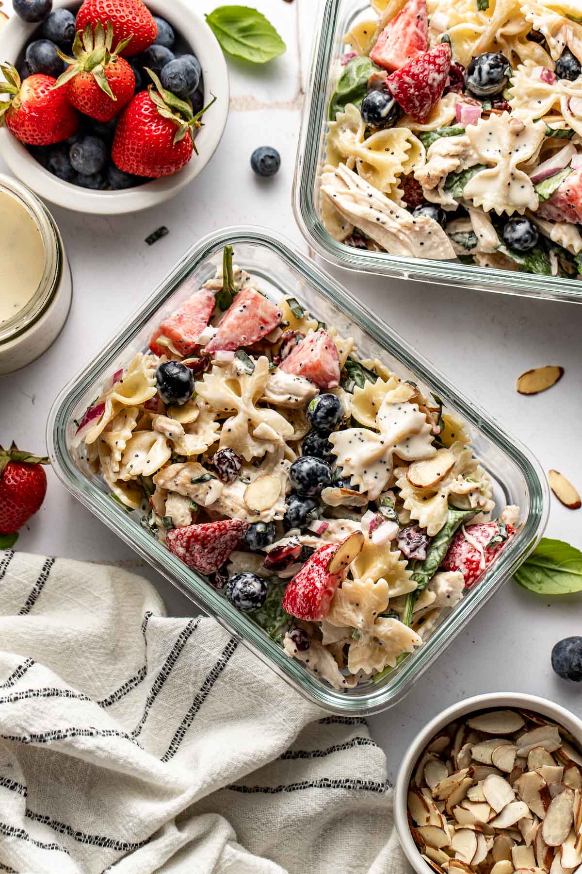 Overhead view of Summer Berry Pasta Salad with Chicken in two glass meal prep containers. 